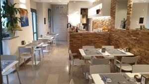 ein Restaurant mit weißen Tischen und Stühlen und einer Theke in der Unterkunft Mura 5&7 in Triest