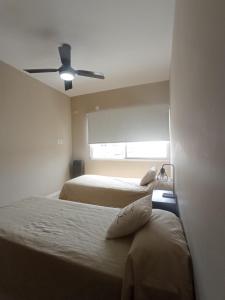 una camera con 2 letti e un ventilatore a soffitto di JUMALETO-Mateo a San Pedro