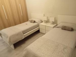 a bedroom with two beds and a night stand at CarloAlbertoApartmentsrooms in Ancona