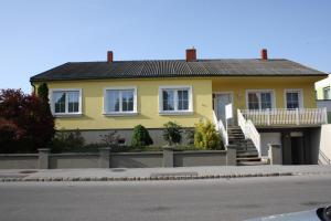 ein gelbes Haus an der Seite einer Straße in der Unterkunft Gästehaus zum See in Illmitz