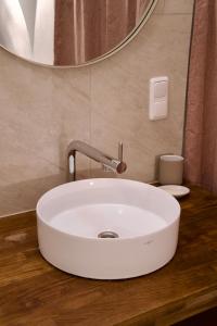 een witte wastafel in een badkamer met een spiegel bij exquisit home in historic vault in Gmunden