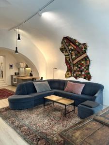 a blue couch in a living room with a table at exquisit home in historic vault in Gmunden