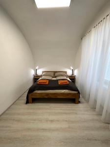 グムンデンにあるexquisit home in historic vaultの白いカーテンが備わるベッドルーム1室のベッド1台が備わります。