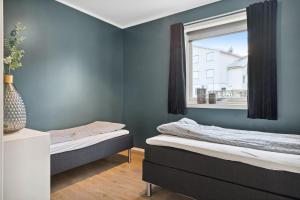 um quarto com 2 camas e uma janela em Large villa in Lofoten with fantastic views - 4 bedrooms and 9 beds. em Stamsund