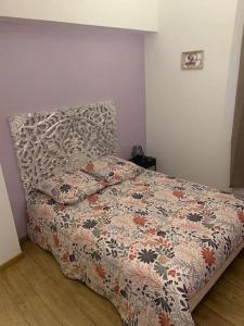 een slaapkamer met een bed met een bloemendeken erop bij T4 en centre-ville, proche gare avec parking in Valenciennes