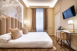 una camera d'albergo con letto e scrivania di Hotel Ungherese Small Luxury Hotel a Firenze