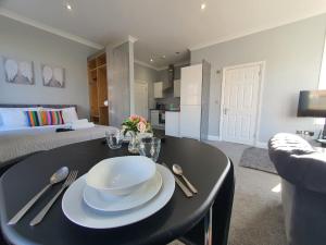 een woonkamer met een tafel met borden en bestek bij Beautiful Maidstone Gem - Sleeps 2 in Kent