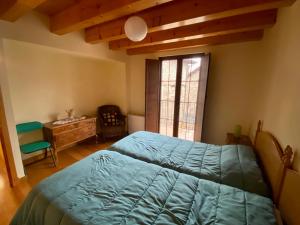 a bedroom with a bed and a desk and a window at Aisa Casa Simon in Aísa