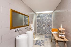 bagno con vasca, lavandino e specchio di Casas Casal de Nino a Celorico de Basto