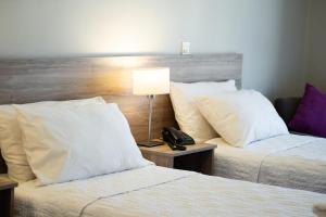 una habitación de hotel con 2 camas y un teléfono en una mesa en Lagos Andinos en San Carlos de Bariloche