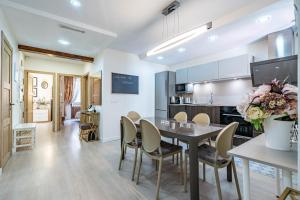 Central luxury flat with free parking في فالنسيا: مطبخ وغرفة طعام مع طاولة وكراسي