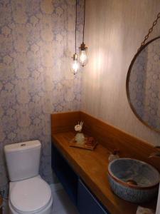 ein Badezimmer mit einem WC, einem Waschbecken und einem Spiegel in der Unterkunft Apartamento novo centro de Canela in Canela