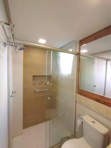 ein Bad mit einem WC und einer Glasdusche in der Unterkunft Apartamento novo centro de Canela in Canela