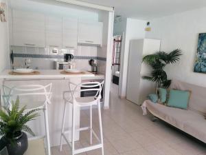 eine Küche und ein Wohnzimmer mit einem Sofa und einem Tisch in der Unterkunft Casa Naturaleza 2 in Caleta de Fuste