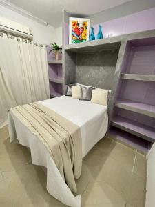 ein Schlafzimmer mit einem großen Bett mit lila Wänden in der Unterkunft claussporto in Porto De Galinhas