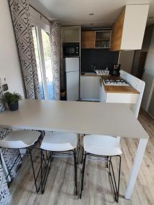 eine Küche mit einem großen weißen Tisch und Stühlen in der Unterkunft Ferienpark Auf dem Simpel - Heide-Lodge 3 in Soltau
