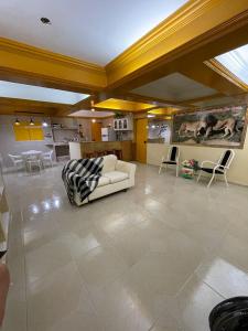 ein großes Wohnzimmer mit einem weißen Sofa und Stühlen in der Unterkunft claussporto in Porto De Galinhas