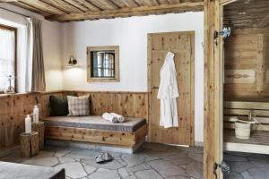 ein Bad mit einem Bett und einem Waschbecken in einem Zimmer in der Unterkunft Feriendorf Holzlebn in Großarl