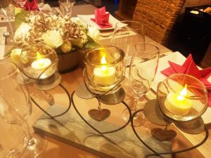 - une table avec des verres à vin et des bougies dans l'établissement Maison de vacances "Les clefs du pont des fées", à Gérardmer