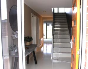 a staircase in a house with a table in a hallway at Sunny Modern 3 Bedroom Townhouse in Newnham