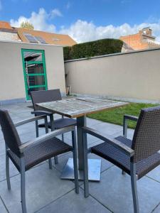 une table et des chaises assises sur une terrasse dans l'établissement Woning met 4 slaapkamers, à Zelzate