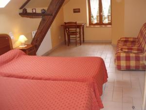 a bedroom with two beds and a staircase with a table at Chambres D'Hôtes De Froulay in Couesmes-vauce