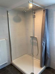 La salle de bains est pourvue d'une douche avec une porte en verre. dans l'établissement Woning met 4 slaapkamers, à Zelzate