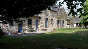 ein Steinhaus mit einem Tisch und Stühlen im Hof in der Unterkunft Chambres D'Hôtes De Froulay in Couesmes-vauce