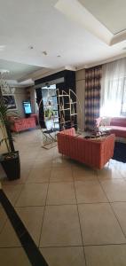 a living room with a red couch and a chair at Hotel Daytona Palace in Casoria