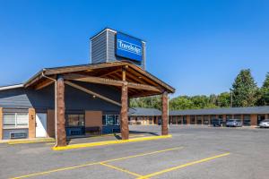 a building with a sign in a parking lot at Travelodge by Wyndham Livingston in Livingston