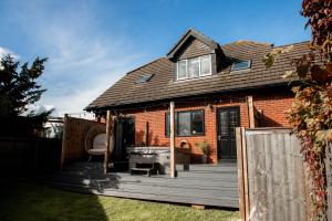 a house with a wooden deck in the yard at Cameo Cottage 