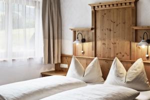 1 Schlafzimmer mit 2 Betten und weißen Kissen in der Unterkunft Feriendorf Holzlebn in Großarl