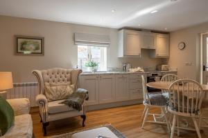 a kitchen and living room with a table and chairs at Feathered Nest in Ripon