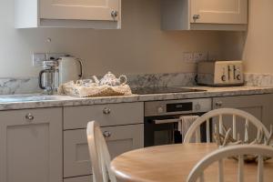 a kitchen with a table and a counter top at Feathered Nest in Ripon