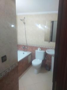 een badkamer met een toilet en een wastafel met een douche bij Fes in Fès