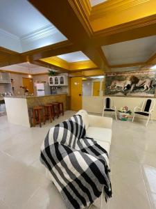 ein Wohnzimmer mit einer schwarzen und weißen Decke auf einer Couch in der Unterkunft claussporto in Porto De Galinhas