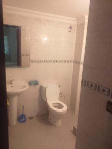 een badkamer met een wit toilet en een wastafel bij Fes in Fès