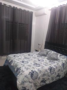 een slaapkamer met een bed met een witte en blauwe deken bij Fes in Fès