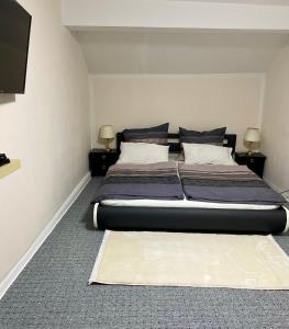 1 cama grande en una habitación con 2 lámparas en Ferienhaus Dakaj - Einfamilienhaus, en Trier