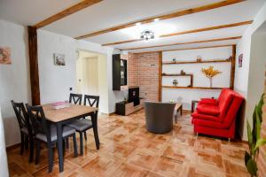 a living room with a table and a red chair at Kuća za odmor Petra in Ludbreg