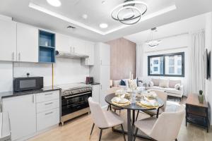 a kitchen and living room with a table and chairs at Nasma Luxury Stays - Home-Style 2BR Apartment with a Balcony View in Dubai