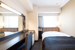 Postel nebo postele na pokoji v ubytování APA Hotel TKP Nippori Ekimae