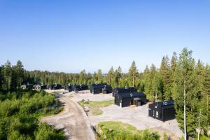 a row of black cabins in a forest at Himoskuutio 8, erillistalo, ulkoporeallas in Jämsä