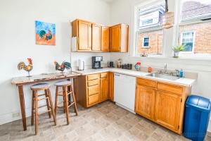 a kitchen with wooden cabinets and a sink at Step Back in Time Charming Victorian with Modern Amenities in Homestead