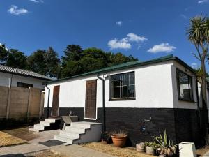 una casa blanca y negra con escaleras delante en BDN Backpackers, en Johannesburgo
