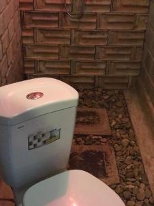 La salle de bains est pourvue de toilettes blanches et d'un mur en briques. dans l'établissement Highway 20 Homestay, à Phong Nha