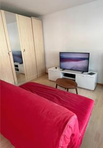 uma sala de estar com um sofá vermelho e uma televisão de ecrã plano em Marmotta 13 em Leukerbad