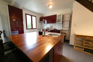 uma cozinha com um balcão de madeira e um lavatório em Milly's House - Charming & Cosy em Milly-la-Forêt