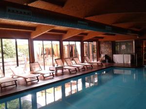 
a hotel room with a pool, chairs, and a pool table at Hotel & Spa Casa Irene in Arties
