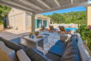 a patio with a couch and chairs and a pool at Lilac Lilium Artistsvillas in Gaios